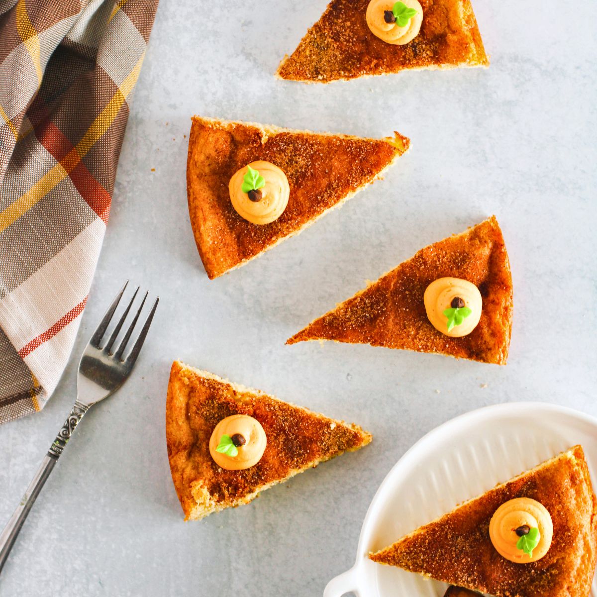 Snickerdoodle cookie pie with frosting pumpkins on top on a counter. 