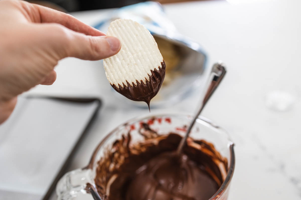 potato chip dipped in milk chocolate A potato chip being dipped in melted chocolate.
