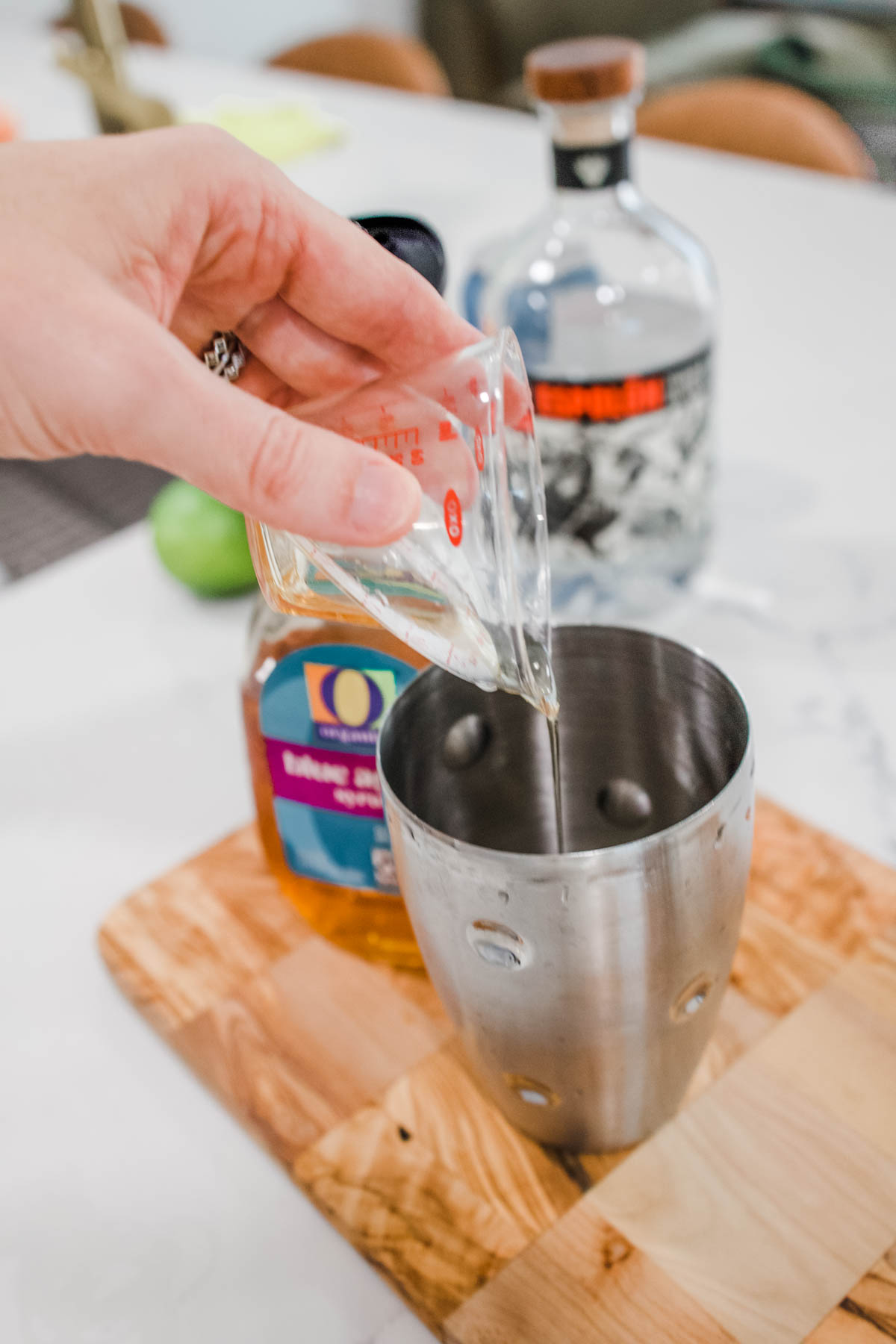 agave syrup Woman's hand adding agave syrup to a cocktail shaker.