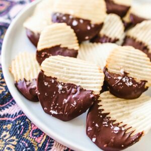 Sea salt on top of potato chip covered in chocolate on a plate for serving.