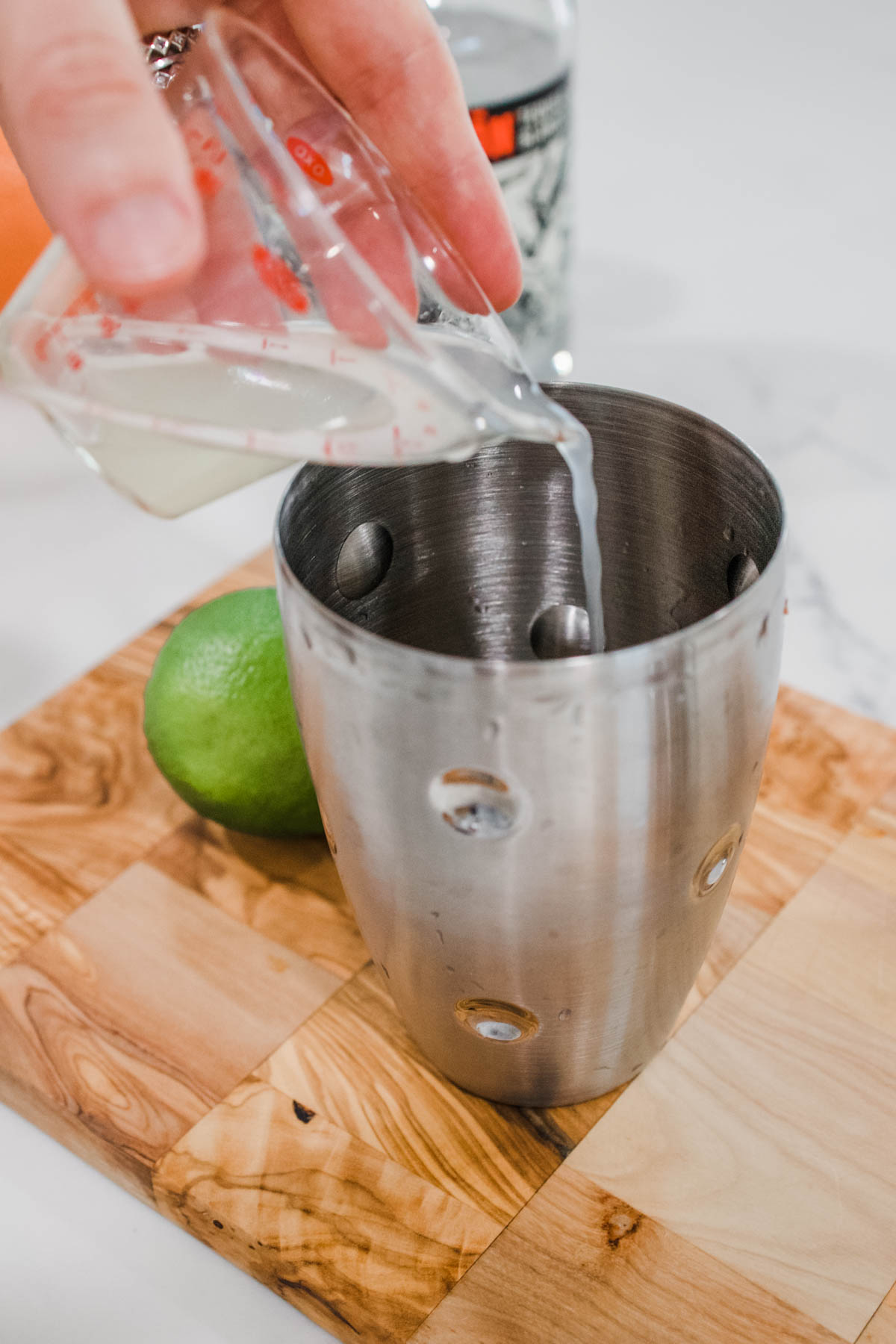 Fresh lime juice being added Fresh lime juice being added to a cocktail shaker.