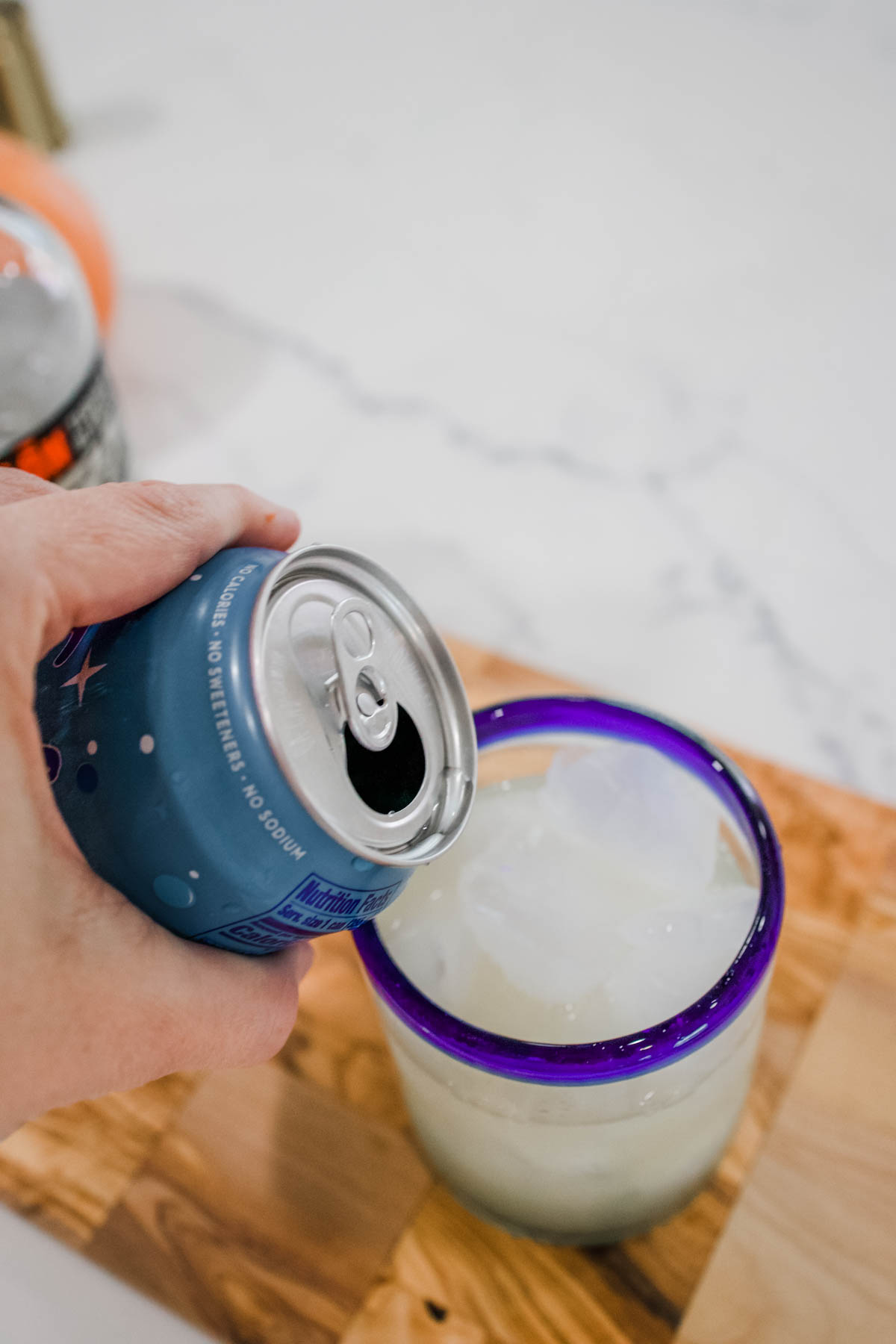 can of sparkling water A can of sparkling water being poured into a cocktail glass.